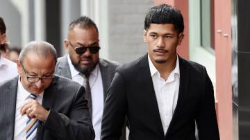 Ex-NRL player Junior Amone outside Wollongong courthouse last year with defence lawyer Elias Tabchouri (left) and father Senior Amone (behind). Picture by ACM