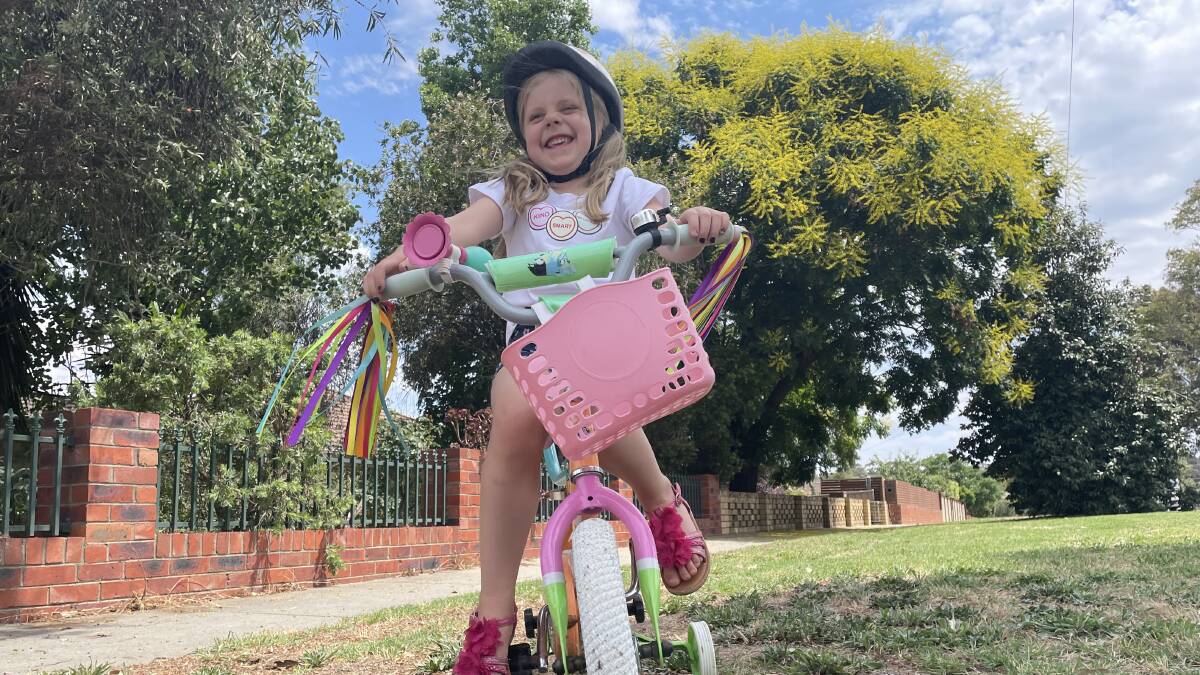 Josephine White, aged 4, on her bike with training wheels in Bendigo, Victoria in December 2023. Picture by Tom O'Callaghan