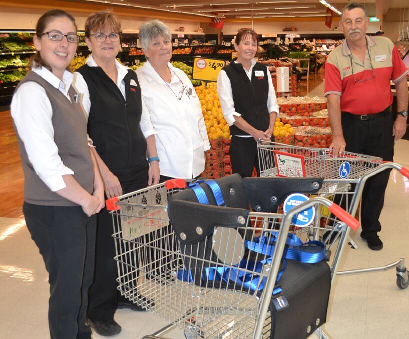 GREAT HELP: Coles store manager Amanda Wright and staff members Tracey Smith, Cindy Waterford, Lea Sponberg and Dennis Wallace with the new trolley. 