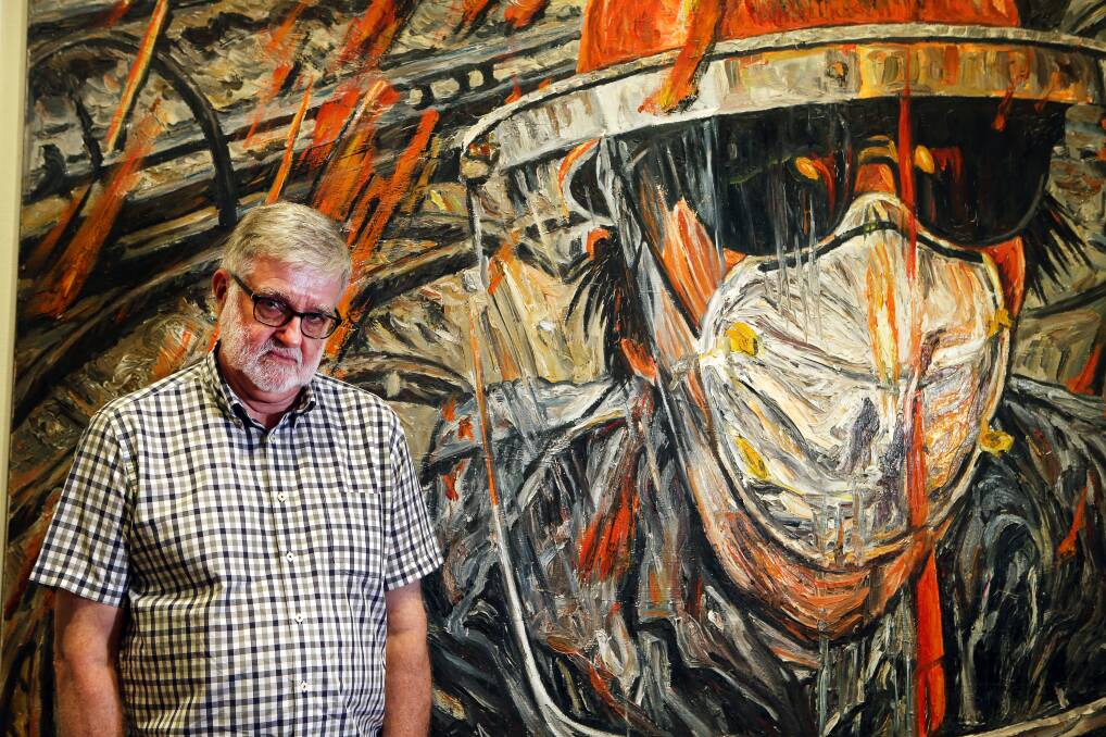 University of Wollongong's Dr Glenn Mitchell with a work by George Gittoes, which features in a steelworks-themed exhibition at the Wollongong Art Gallery. Picture: Sylvia Liber