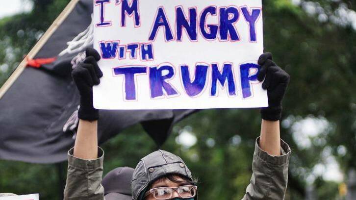 People hold placards during a protest against US President Donald Trump and his recent policies outside the American Embassy in Jakarta. Photo: Jefri Tarigan 