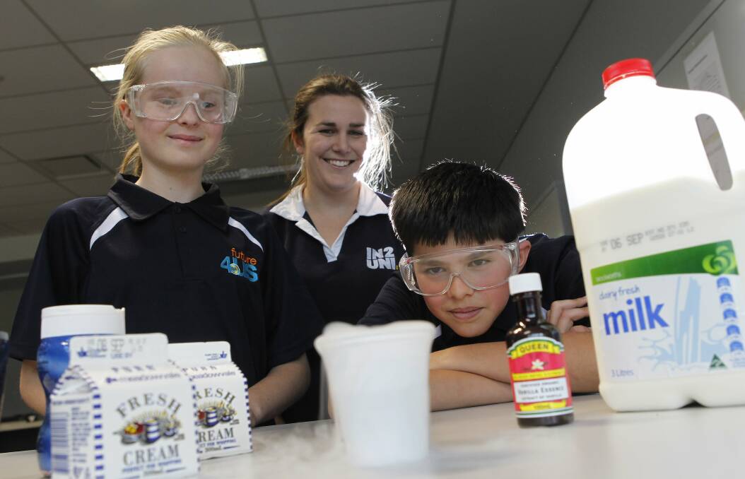 EDUCATION: Kimberley Abbott as an engineering mentor at UOW's Smart Building in 2012 with year 6 students Emelia Susnja and Jacob Figliomeni. They are trying to create ice cream using liquid nitrogen. Photo: ANDY ZAKELI