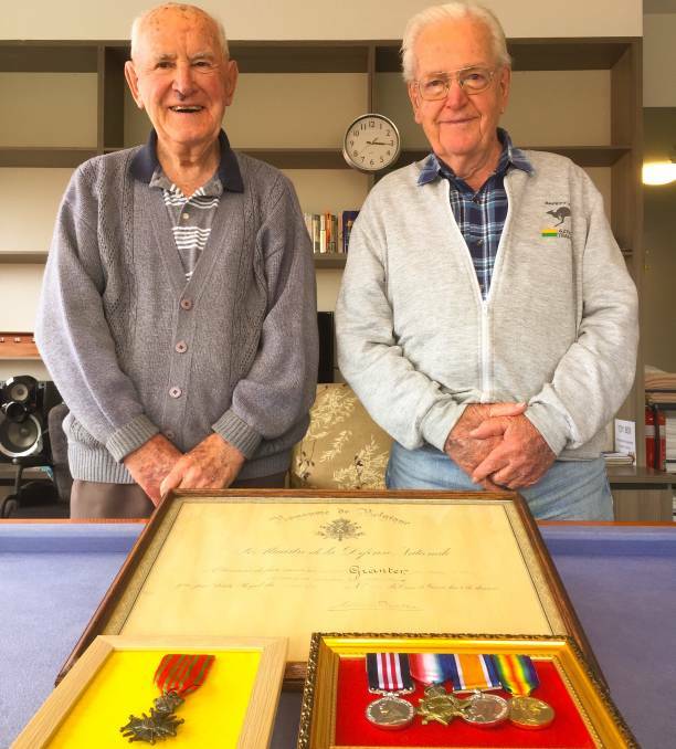 Brothers Murray (left) and Jack Granter with their father's medals, including his Belgian Croix de Guerre, and diploma from the Belgian government.
