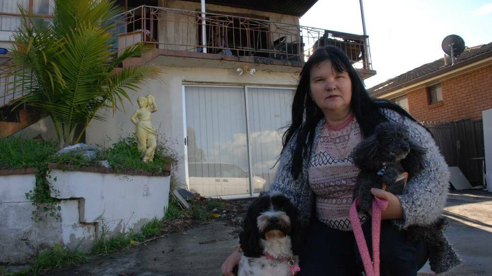 Susan Brown keeps pooches Lylah and Axel close after fire broke out on her home's upstairs verandah. Pictures: Angela Thompson