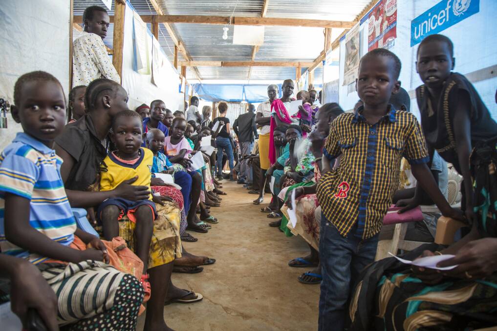 CRISIS: Internally displaced children and women wait in the UNICEF-supported clinic run by the International Medical Corps at the Protection of Civilians (PoC) site in Juba on July 22. Photo: © UNICEF / Gonzalez Farran