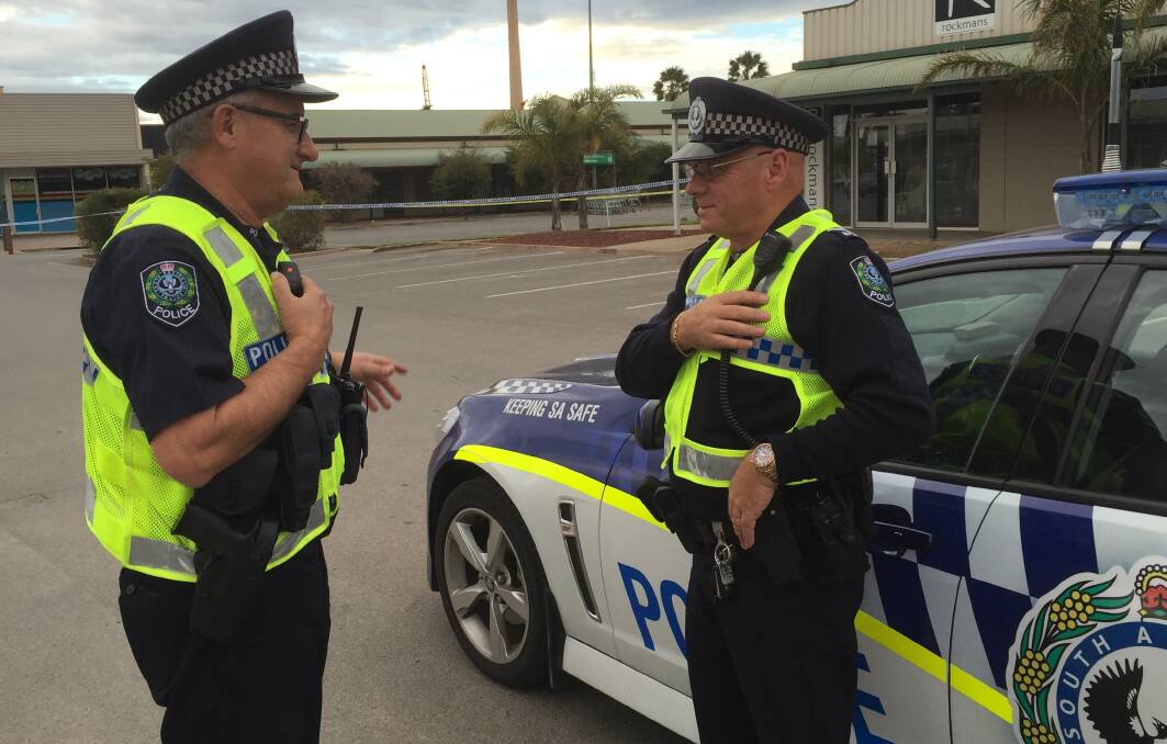 POLICE: Senior Constable Peter O'Neill, left, and Senior Constable Allan Bourke discuss the security arrangements near the site of the suspicious package.