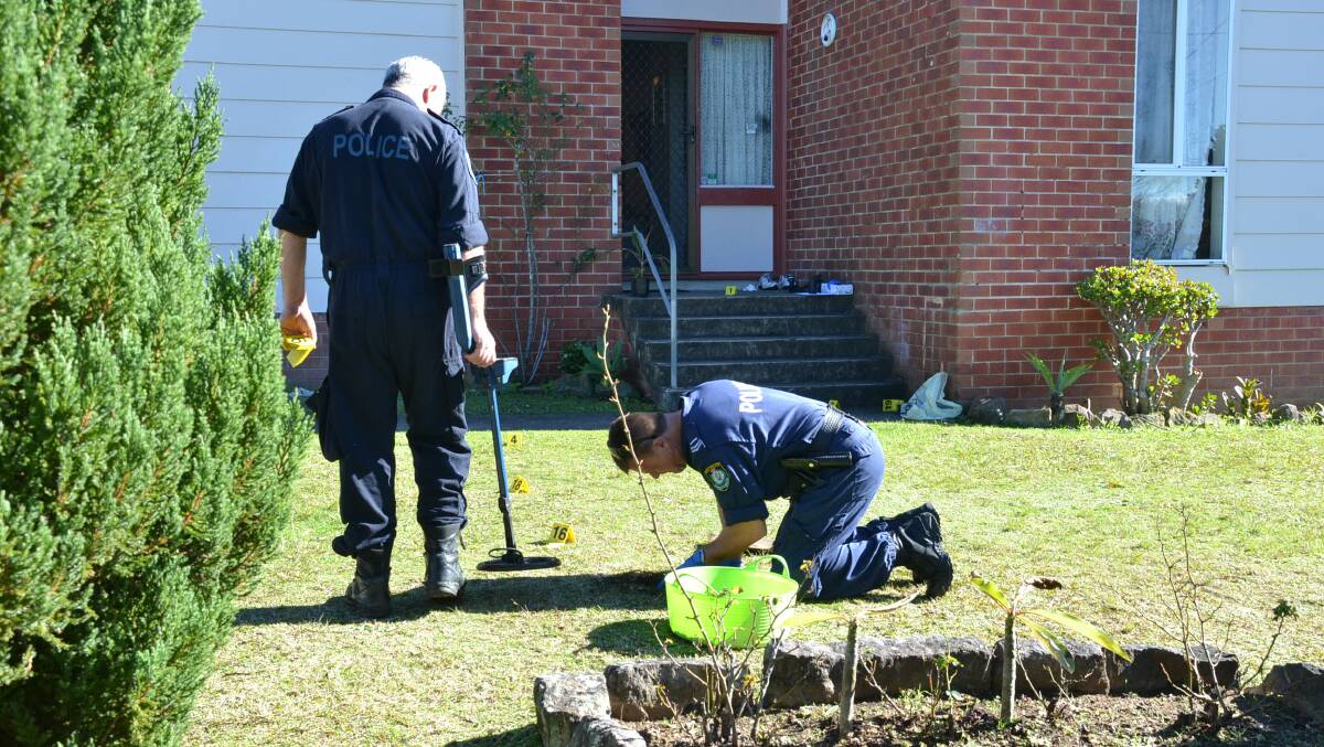 CRIME SCENE: Police search for evidence outside the home in North Nowra.