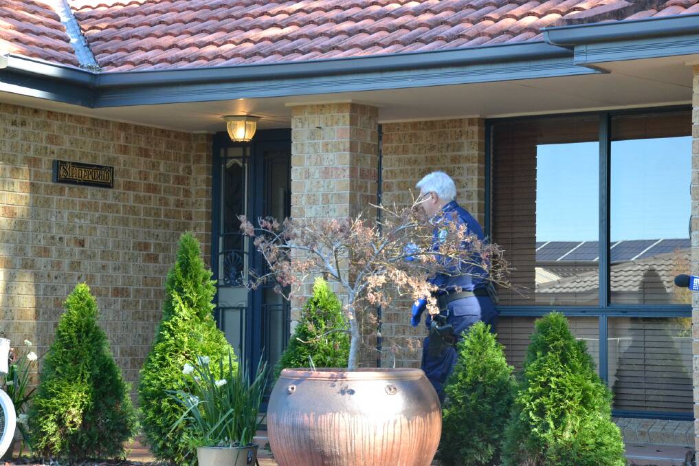 A forensic officer at the Worrigee home in Bluewattle Road after last Wednesday's home invasion.
