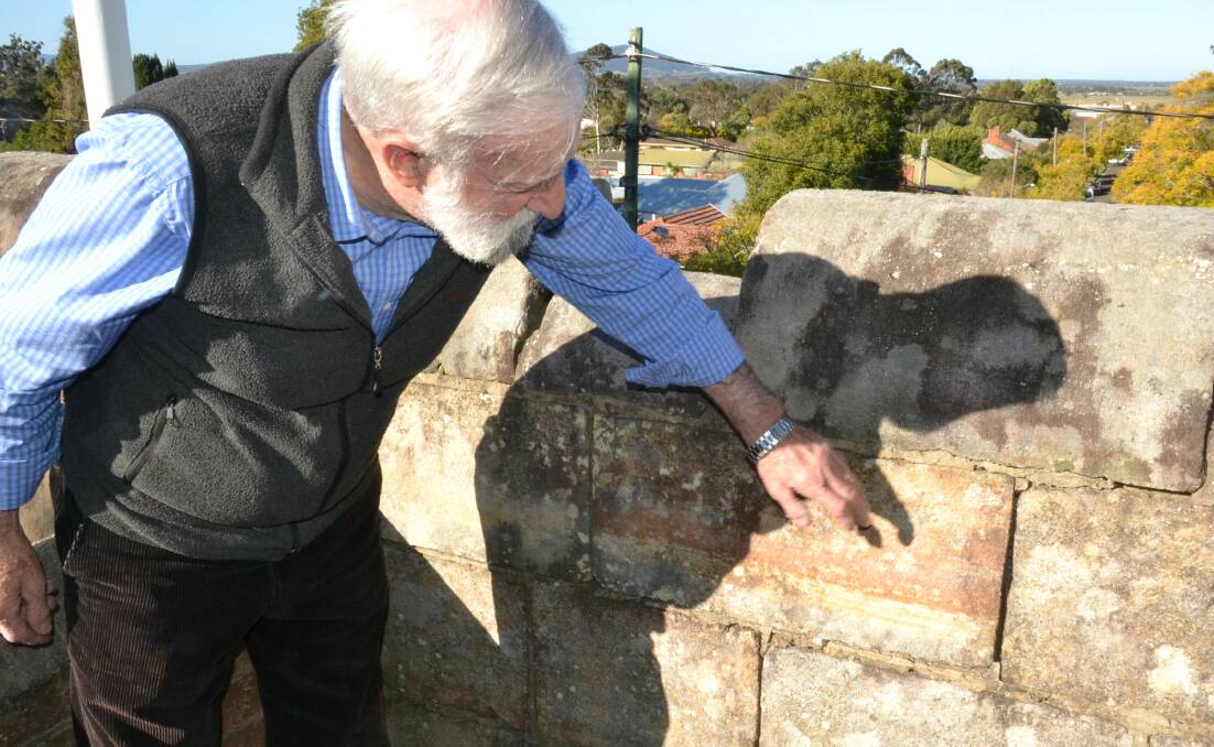 Nowra RSL Sub-Branch president Fred Dawson inspects some of the damage at the top of the Nowra War Memorial.



