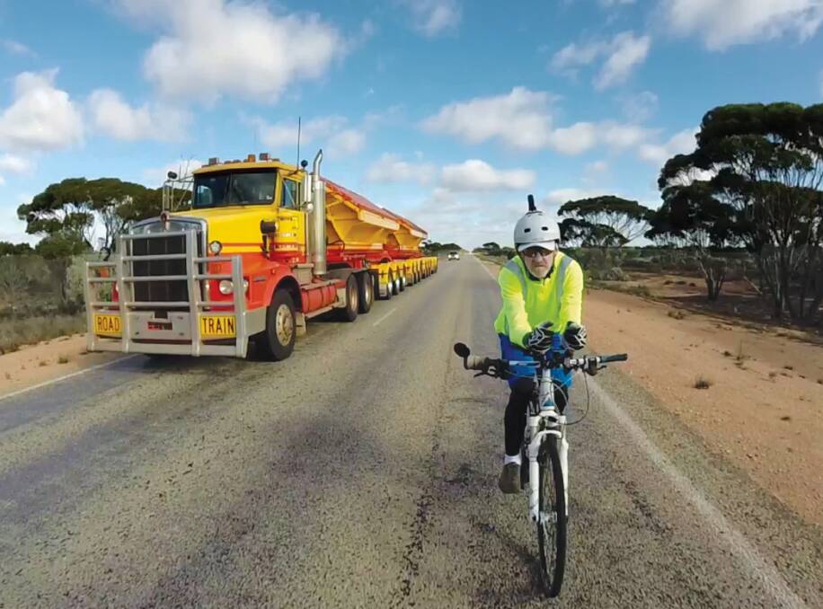 ON THE ROAD: Local author Michael Davey on Australia's longest straight stretch of highway in WA, the Eyre Highway (145.6 kilometres). The photo is the front cover of his book Journey of Charity and was captured from the video taken from the rear of his support vehicle's trailer. 