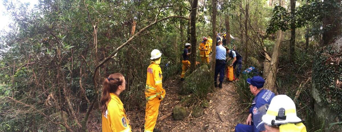 Emergency services work to recover the injured man from 15 metres over the side of the Drawing Room Rocks walking track. Photo: Shoalhaven Heads Rural Fire Service