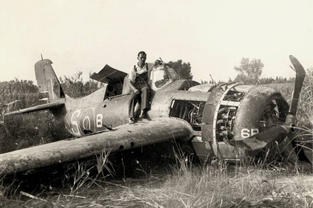 A villager sits on Fred Sherborne's downed Grumman Wildcat not long after it crashed near Avignon in southern France on August 19, 1944.