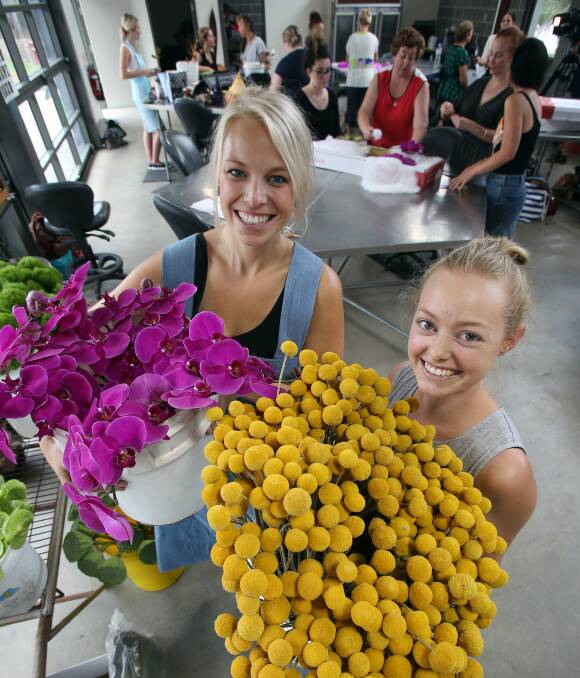BUDDING FLORISTS: TAFE Illawarra Yallah students Katlyn Stone and Jenna Spyve pulling together some of the hundreds of flowers to take to Sydney for their team's entry at the Royal Easter Show. Picture: Robert Peet