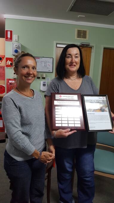 Rachael Niemoeller, the volunteer coordinator for the Red Cross at Narooma, hands over the special award to Lee Barham for her dedication to the IRT residents. 