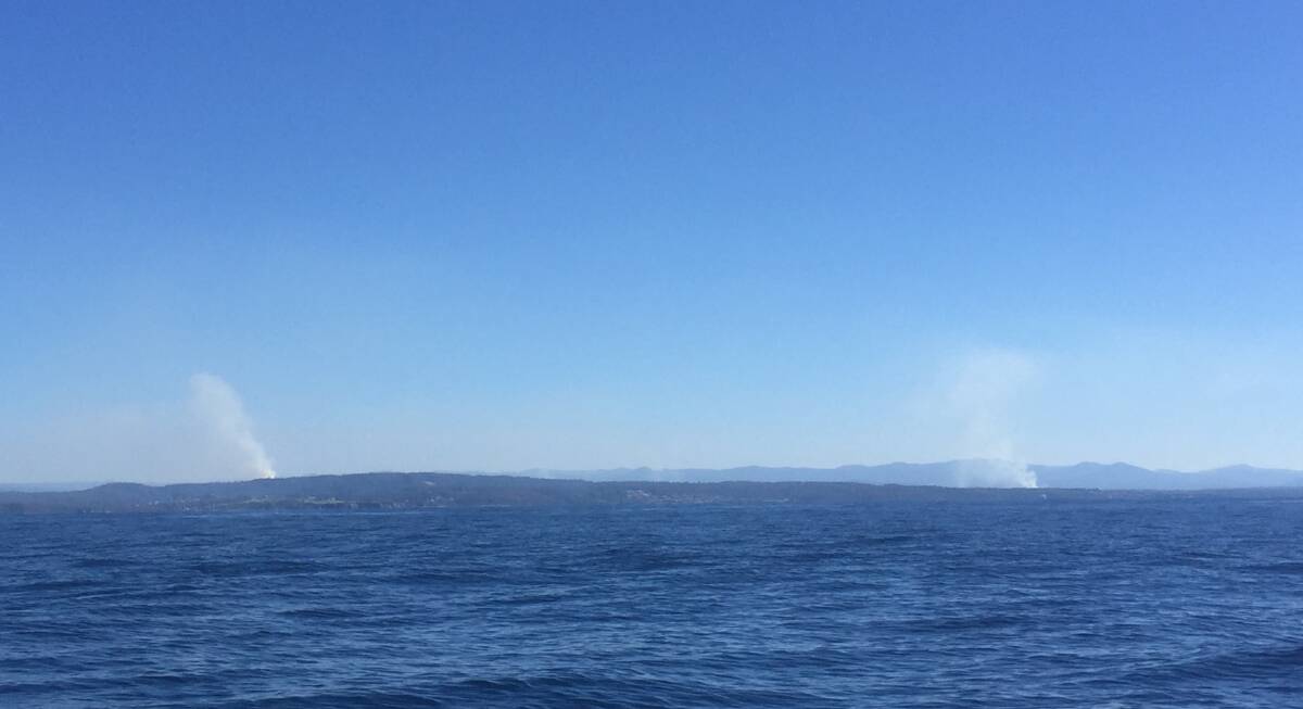 Hazard reduction burns around Narooma and south as seen from Montague Island on Sunday. 