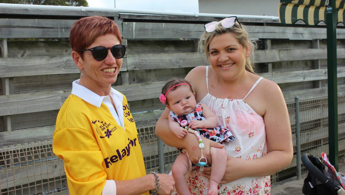 Eurobodalla Relay for Life organising committee member Sue Seath with fellow committee member and cancer survivor Jess Bourke and her new baby Charley. 