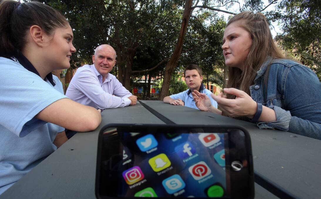Online help: Caitlin Wood, from Project Rockit, and Telstra's Chris Taylor talk about cyberbullying with Corrimal High School students Alex Robert and Ethan Laughlin-Pearce. Picture: Robert Peet