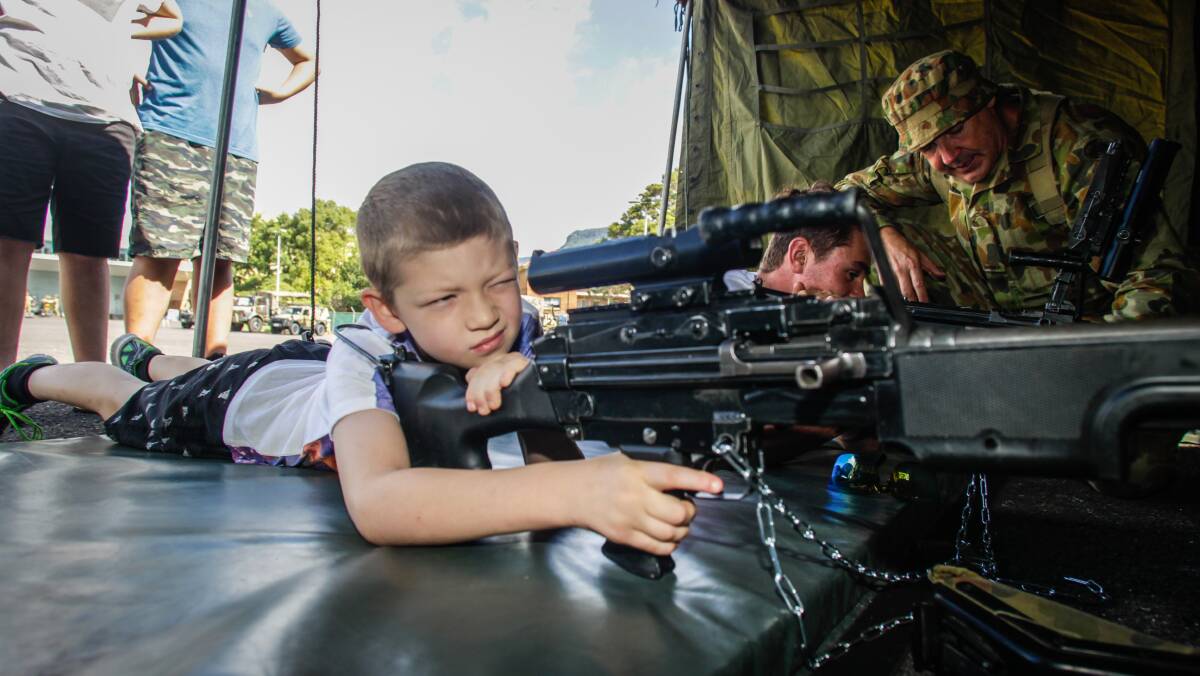 EYE ON THE TARGET: Dylan Mumberson gets his hand on a machine gun displayed at the Army Reserve open day in Wollongong. Picture: Georgia Matts