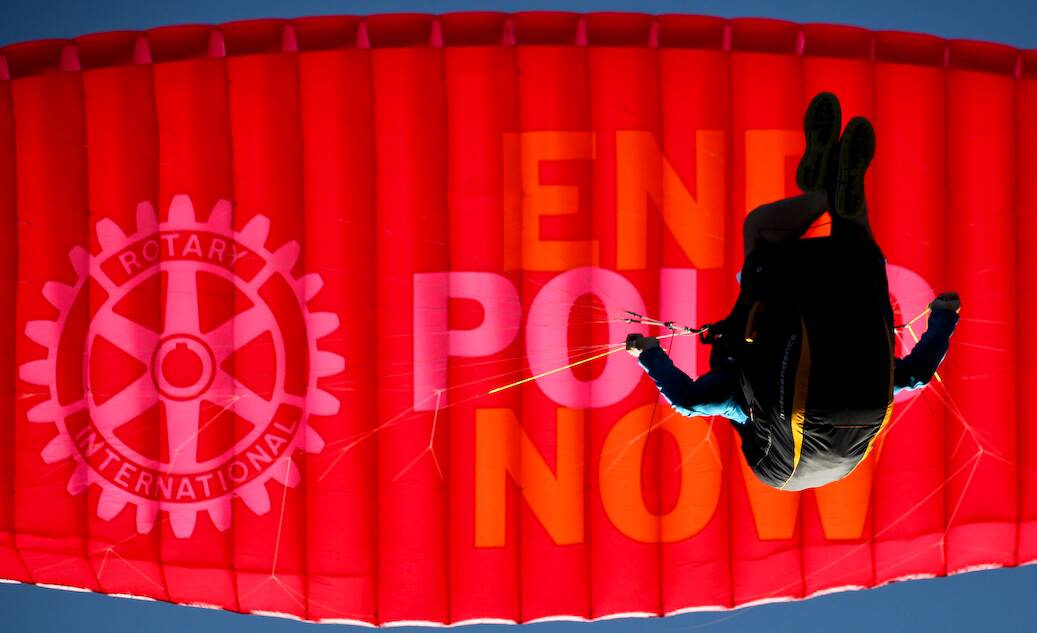 Message in the sky: Ken's bright red paraglider, which carried the Rotary logo and the words "End polio now", was shown to Rotarians at last week's dinner.
