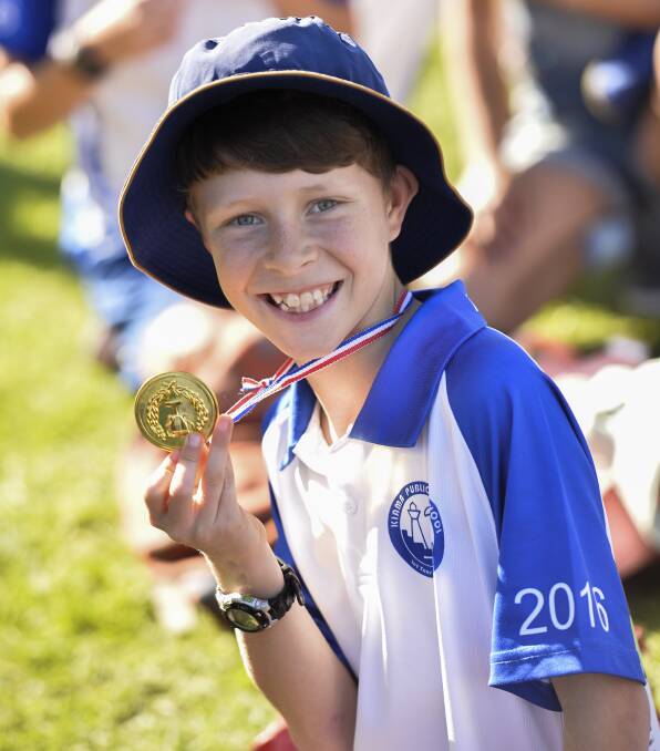 Brendan Springett proudly displays his gold medal. Events included on-land synchronised swimming, Aussie gumboot throwing and human hurdling. 