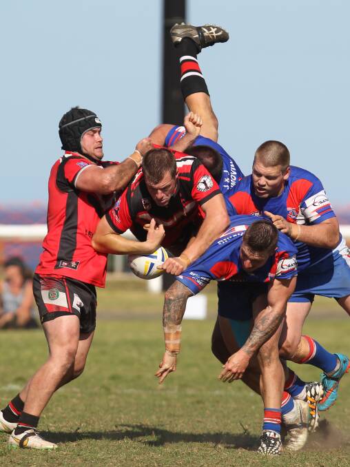 BRUISING BATTLE: Kiama veteran Cam Whittaker is up-ended by the Gerringong defence. Picture: KIAMA PICTURE CO 
