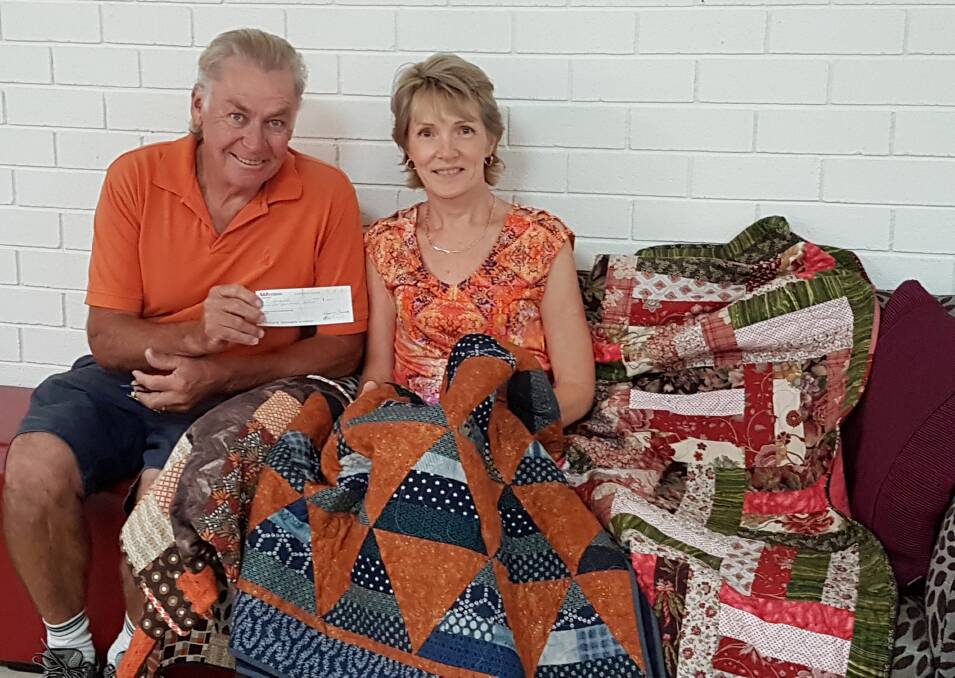 DONATION: Carole Campbell and Friends of Blue Haven Aged Care Facility's Col Rathbone with three of her quilts. Picture: Supplied