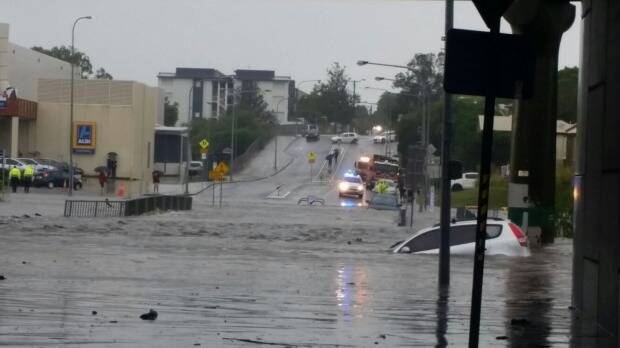 A small hatchback is swept away by flooding in suburban Brisbane. Photo: Jorge Branco
