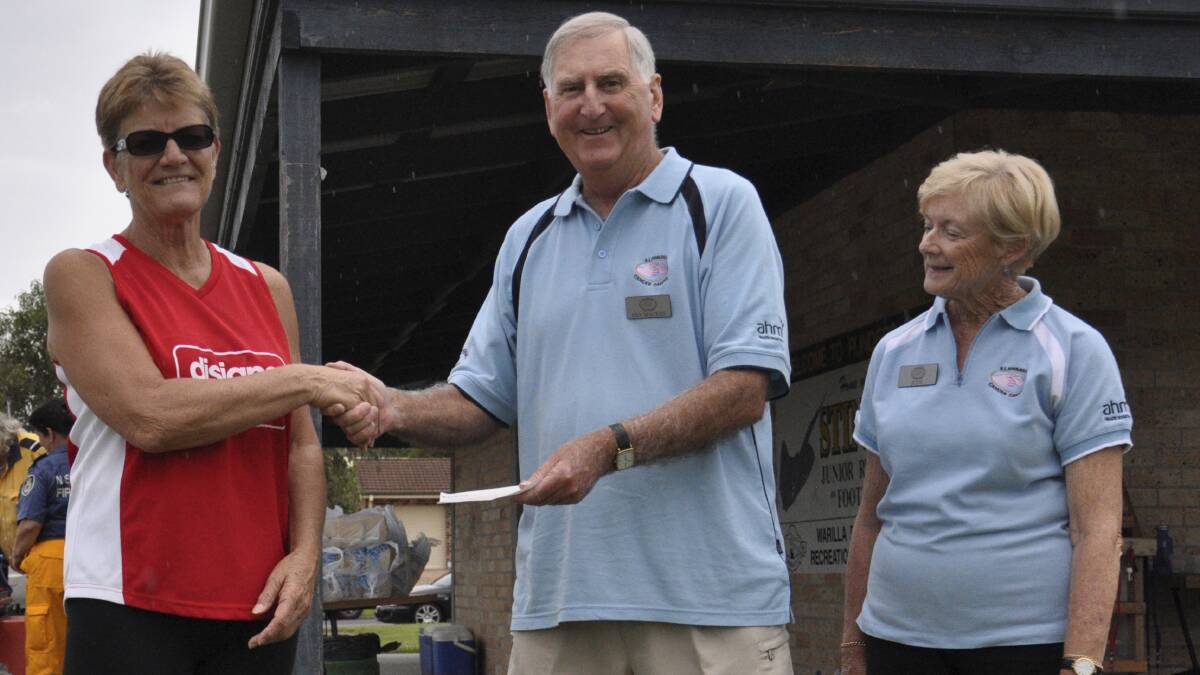 Marilyn Whitfield of Shellharbour City Touch presents a cheque for $1035 to Ian and Judy Mackay from Illawarra Cancer Carers. Picture: WARREN BUTLER