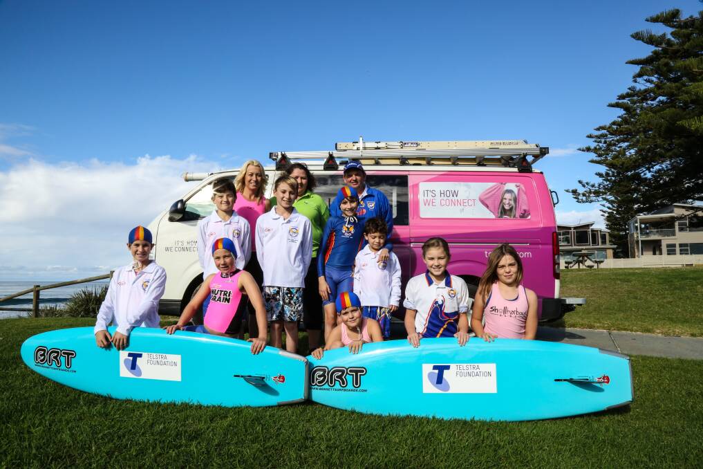 Tammy Coltman, Telstra Illawarra general manager Tricia Wilson and Kevin Coltman with Shellharbour Surf Life Saving Club Nippers and their new rescue boards. Picture: GEORGIA MATTS