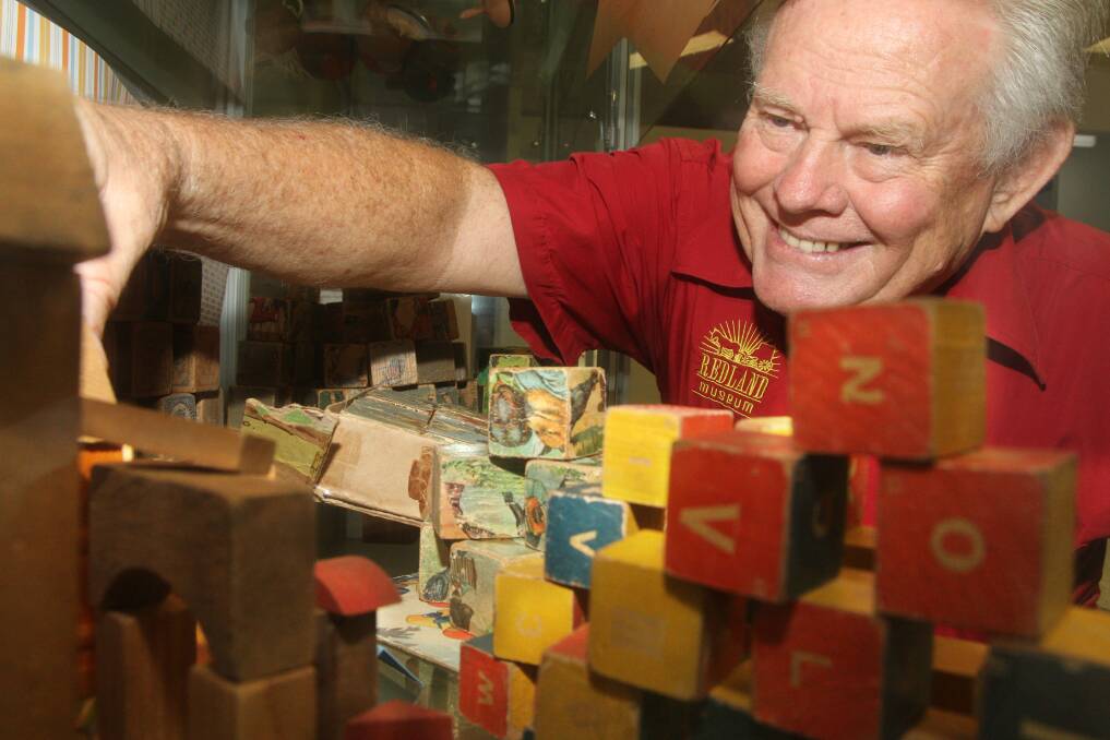 Redland Museum president Ross Bower arranges the historic building blocks in the Australian Toy Hall of Fame at Redland Museum. Photo by Chris McCormack