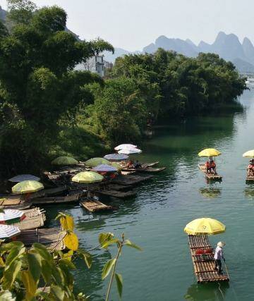 A picturesque punt: Locals travel on bamboo rafts along Yulong River, Guangxi province, China. Photo: Sarah Biggins-Gilchrist