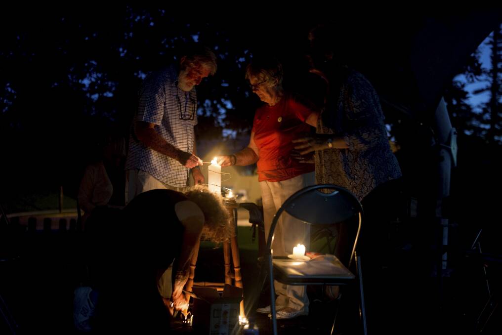 People light candles at Thursday's vigil.