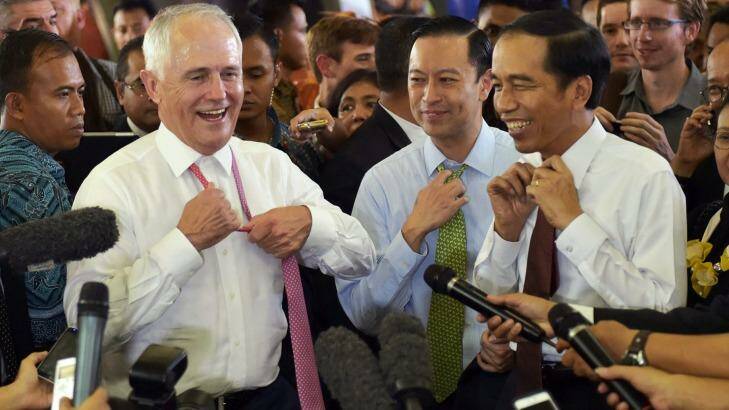 Australian Prime Minister Malcolm Turnbull and Indonesian President Joko Widodo move to take off their ties during a visit to a Jakarta market. Standing between them in the blue shirt is Thomas Lembong. Photo: Pool via AP