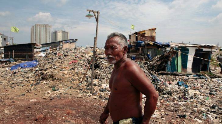 A Kampung Akuarium residents walks through mountains of rubbish and rubble in the makeshift neighbourhood. Photo: Irwin Fedriansyah