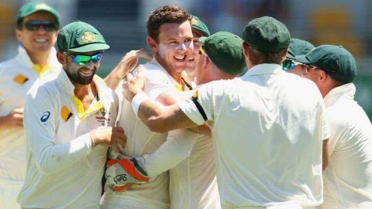 Teammates mob Josh Hazlewood after his first Test wicket.