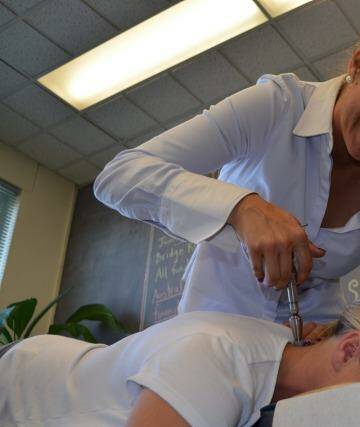 Special treatment: Dr Sarah MacNeil applies an applicator to a patient's spine.