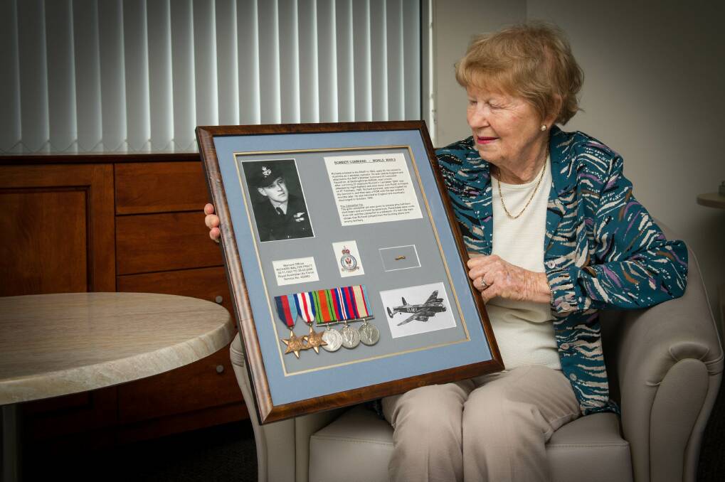 Elaine Pratt admires memorabilia from her late husband, Richard, which she had framed. He died in 2006. Picture: ALBEY BOND
