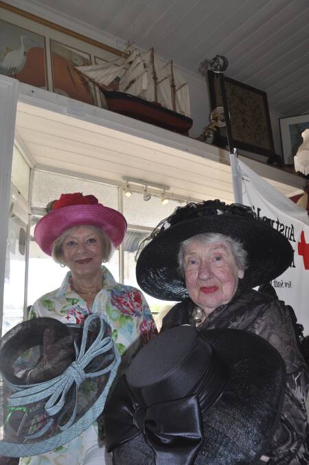 Jamberoo Red Cross members Lesley Curnow and Frances Linnertson show some of the hats the branch is using to raise money for the Red Cross. Picture: PHIL McCARROLL