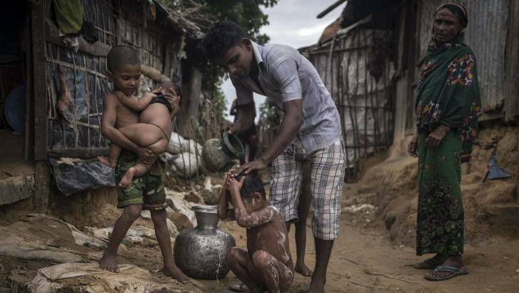 A Rohingya man bathes his child at the Kutupalong Refugee Camp in Teknaaf, Bangladesh. Photo: New York Times