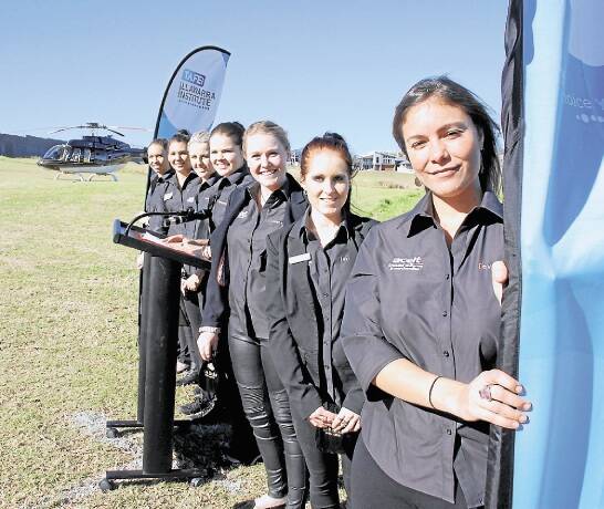 TAFE Illawarra students Joana Figuerredo, Emily Perram, Fiona Greader, Lauren Glennon, Dene Anemogiannis, Renae Fedele and Monica Croziner launch Eventure with the IPG helicopter at Links Shell Cove. Picture: ELIZA WINKLER