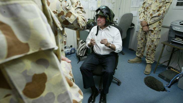 Then prime minister John Howard tries on a night vision helmet while preparing to enter Iraq for Anzac Day in 2004. Photo: Kate Geraghty