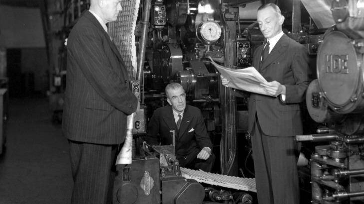 Messrs Denne, Turner and Luft look at the newspapers as they come off the hot press 9th August 1944. Photo: Fairfax Archives