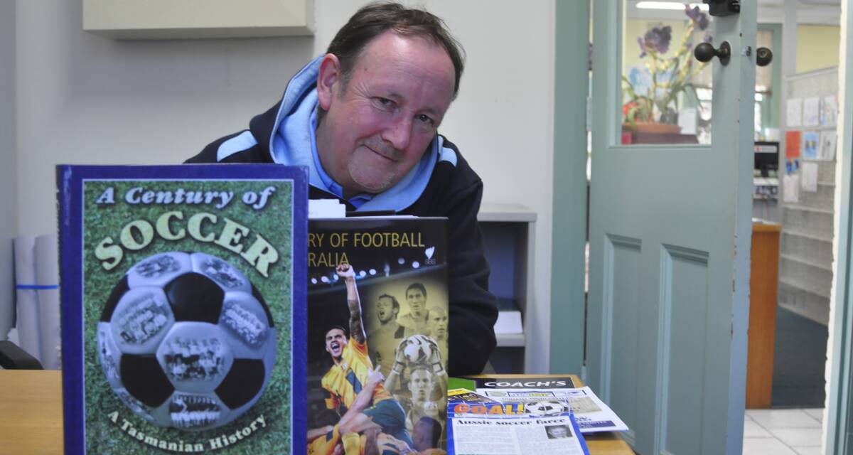 Kiama soccer devotee Chris Hudson with the book he researched, wrote and published.