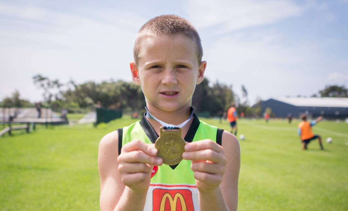 Youngster Taj Ford proudly shows off the gold medal he won at the recent State Little As title in Sydney. Picture: ALBEY BOND