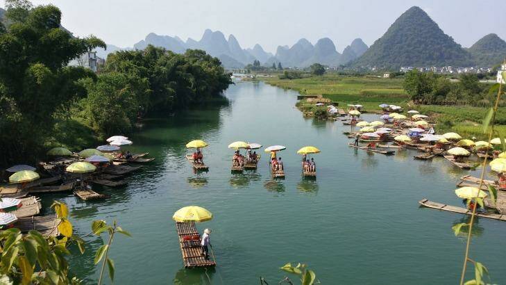 A picturesque punt: Locals travel on bamboo rafts along Yulong River, Guangxi province, China. Photo: Sarah Biggins-Gilchrist