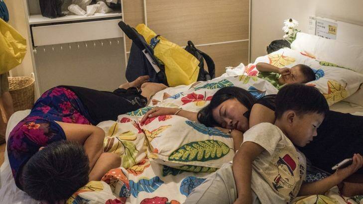 A family takes time to rest on a display bed at an IKEA store in Beijing. Photo: New York Times