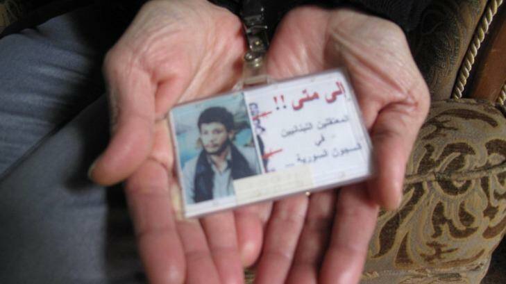 Samia Abdullah holds a card she wears on a lanyard that reads: "Until when!! Lebanese detainees in Syria's jails." Photo: Ruth Pollard