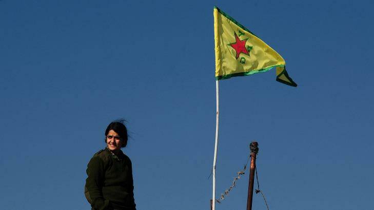 A YPG fighter stands atop a farmhouse near the contested town of Tel Hamis, the yellow YPG flag raised to symbolise the area's liberation from IS.  Photo: Fadi Yeni Turk