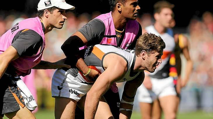 Bumped: Callan Ward of the Giants is helped from the field after he was bumped by Richard Douglas of the Crows in round five. Photo: Morne de Klerk