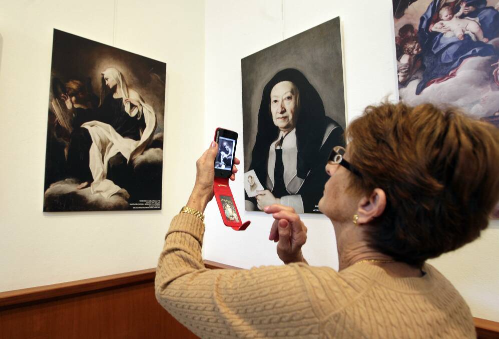Maria Cealini takes a photo of a painting from her home region of Marche, Italy, at the baroque exhibition now showing at Wollongong Art Gallery. Picture: ANDY ZAKELI